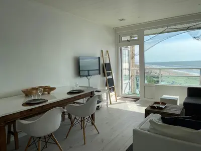 a living room with a table and chairs and a large window at Top View in Zandvoort