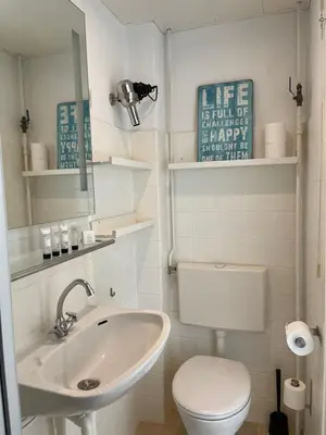 a white bathroom with a toilet and a sink at Top View in Zandvoort