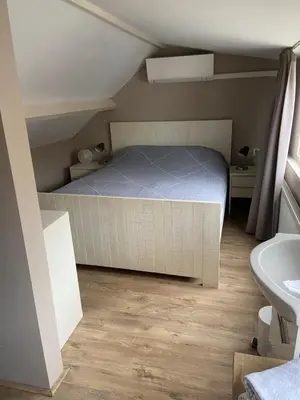 a small bedroom with a bed and a sink at Piet's Beachhouse in Katwijk aan Zee