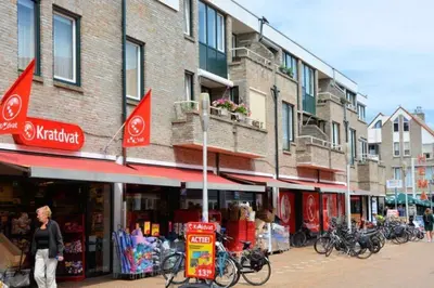 a woman walking down a street in front of a store at Piet's Beachhouse in Katwijk aan Zee