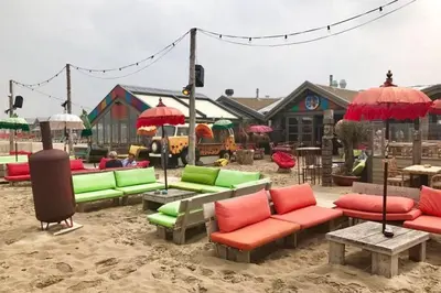 a seating area with colorful chairs and umbrellas at Piet's Beachhouse in Katwijk aan Zee