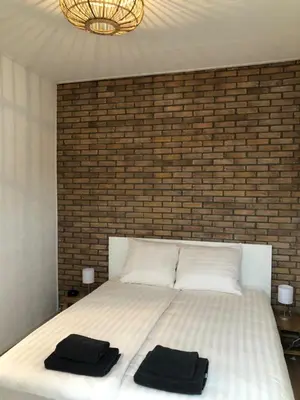 a bedroom with a bed with two black towels on it at Kingstreet Apartment in Zandvoort
