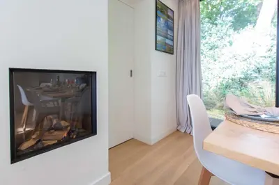 a living room with a television and a table with chairs at 8atsea Deluxe Dune Villa Schoorl in Schoorl