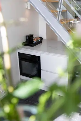 a microwave oven in a kitchen with a staircase at 8atsea Deluxe Dune Villa Schoorl in Schoorl
