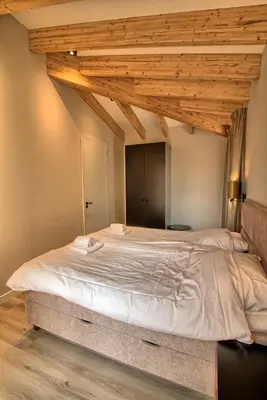 a large bed in a room with wooden ceilings at Najade Resort Het Gooi in Eemnes