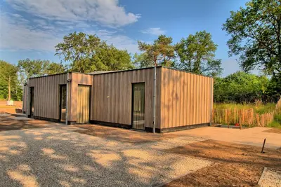 a large metal building with two doors on a lot at Najade Resort Het Gooi in Eemnes