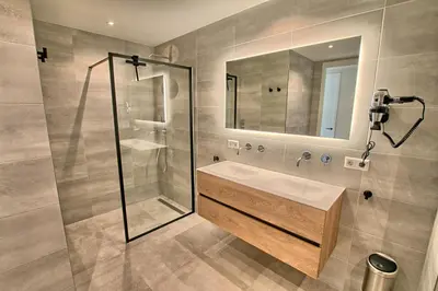 a bathroom with a shower and a sink and a mirror at Najade Resort Het Gooi in Eemnes