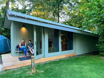 two people sitting on the porch of a tiny house at Camping Vliegenbos in Amsterdam