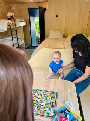 a woman and a baby sitting on beds in a room at Camping Vliegenbos in Amsterdam