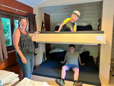 two women and a boy are standing in a bunk bed at Camping Vliegenbos in Amsterdam