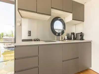 a kitchen with gray cabinets and a sink at Houseboat in Volendam Marina in Volendam