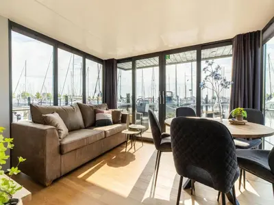 a living room with a couch and a table and chairs at Houseboat in Volendam Marina in Volendam