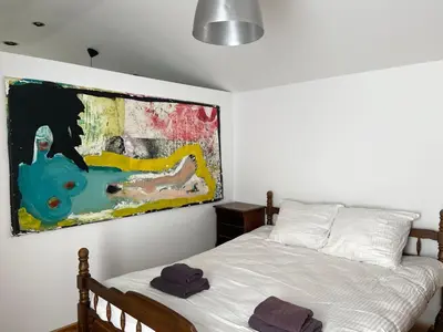 a bedroom with a bed and a painting on the wall at Arthouse Lola in Bergen
