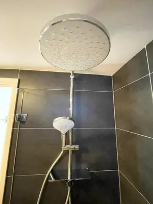 a shower with a shower head in a bathroom at Flinder Amsterdam in Amsterdam