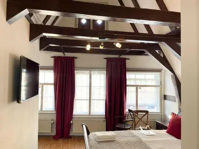a bedroom with red curtains and a bed with a table at Flinder Amsterdam in Amsterdam