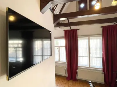 a living room with red curtains and a mirror at Flinder Amsterdam in Amsterdam