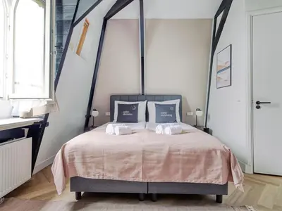 a bedroom with a canopy bed with two pillows at STAYSOME Amsterdam Hemonystraat in Amsterdam