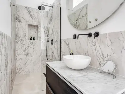 a bathroom with a sink and a shower with a mirror at STAYSOME Amsterdam Hemonystraat in Amsterdam