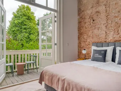 a bedroom with a bed and a brick wall at STAYSOME Amsterdam Hemonystraat in Amsterdam