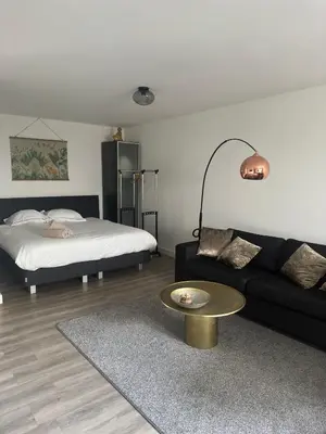 a living room with a couch and a bed at Studio Garden View in Zandvoort