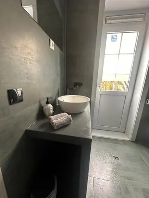 a bathroom with a white sink and a window at Studio Garden View in Zandvoort