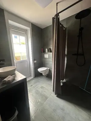a bathroom with a shower and a toilet and a sink at Studio Garden View in Zandvoort
