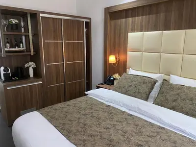 a bedroom with a large bed with a wooden headboard at Hotel Cataleya in Almere