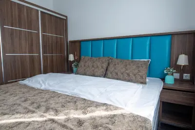 a bedroom with a large bed with a blue wall at Hotel Cataleya in Almere