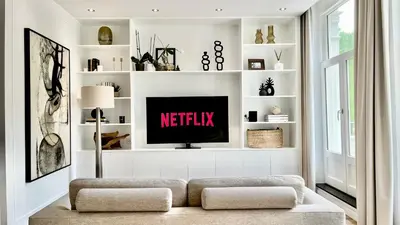 a living room with a tv and white shelves at New stylish 1 bedroom apt w/ 2 balconies in Centrum in Amsterdam