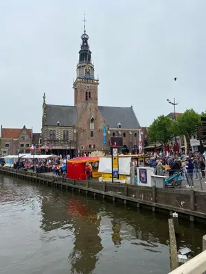 a large building with a clock tower next to a river at King Suite Centre Alkmaar in Alkmaar