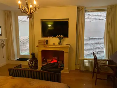 a living room with a fireplace and a tv at King Suite Centre Alkmaar in Alkmaar
