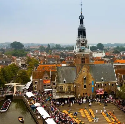 a crowd of people standing in front of a building with a clock tower at King Suite Centre Alkmaar in Alkmaar