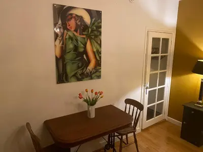 a dining room with a table and a painting on the wall at Queen Suite Centre Alkmaar in Alkmaar