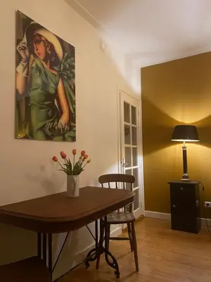 a dining room with a table and a painting on the wall at Queen Suite Centre Alkmaar in Alkmaar