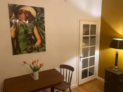 a dining room with a table and a painting on the wall at Queen Suite Centre Alkmaar in Alkmaar