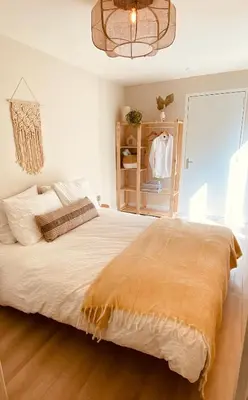 a bedroom with a large bed and a chandelier at Casita aan Zee 2 slaapkamers 2 badkamers 3 min van zee in Zandvoort
