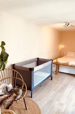 a bedroom with a crib and a bed at Casita aan Zee 2 slaapkamers 2 badkamers 3 min van zee in Zandvoort