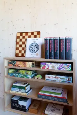 a book shelf filled with books and a pile thereof at Noorderbed in Amsterdam