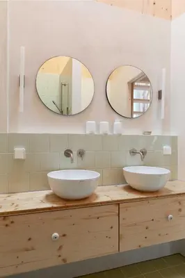 two sinks on a counter in a bathroom with mirrors at Noorderbed in Amsterdam