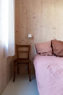 a bedroom with a bed and a chair and a lamp at Noorderbed in Amsterdam