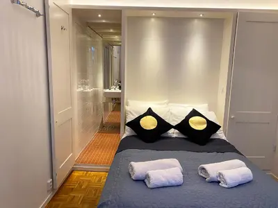 a bedroom with a bed with two pillows and a shower at Canal Hideaway in Amsterdam