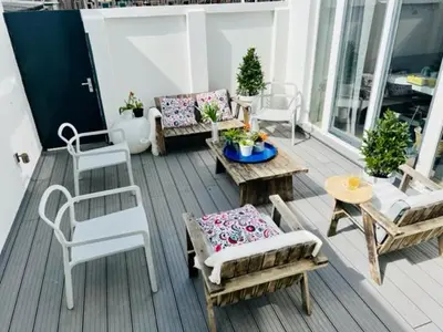 a patio with chairs and tables on a balcony at Family Beach House Zandvoort City Center in Zandvoort