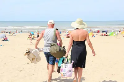 a man and a woman walking on the beach at Molecaten Park Noordduinen in Katwijk