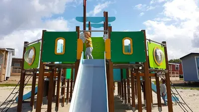 a young boy is climbing on a playground at Molecaten Park Noordduinen in Katwijk