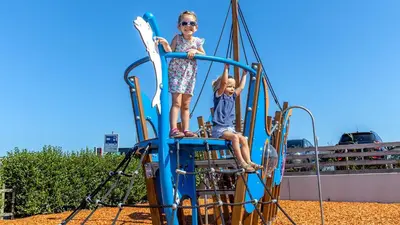 two children riding on a playground equipment at Molecaten Park Noordduinen in Katwijk