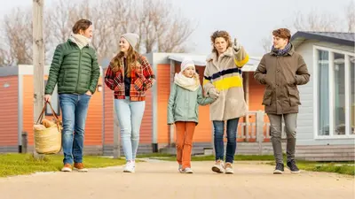 a group of people walking down a sidewalk at Molecaten Park Noordduinen in Katwijk
