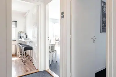 a room with a door leading to a kitchen with a mirror at familie Zwinkels in Zandvoort