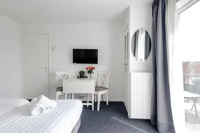 a bedroom with two beds and a table and a television at familie Zwinkels in Zandvoort