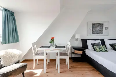 a bedroom with a bed and a table and chairs at familie Zwinkels in Zandvoort