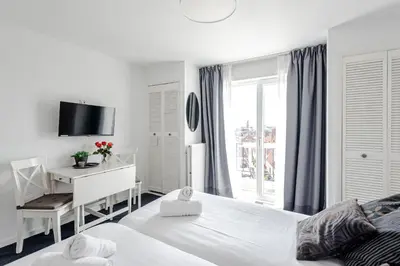 a bedroom with two beds and a desk and a window at familie Zwinkels in Zandvoort